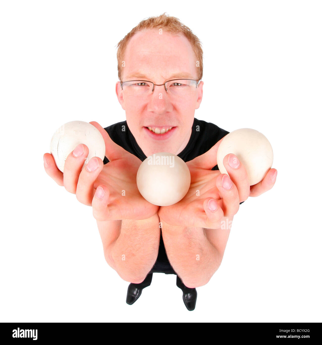 junger Mann mit drei Bällen jonglieren Stockfoto