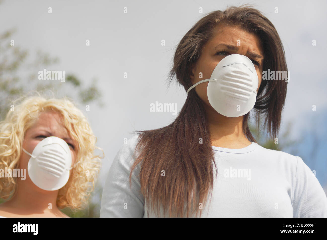 zwei junge Frauen in Straße trägt schützende Gesicht Filtermasken Stockfoto