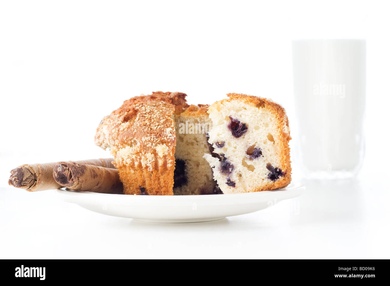 In Scheiben geschnitten Muffin in einem weißen Teller mit einem Glas Milch im Hintergrund Stockfoto
