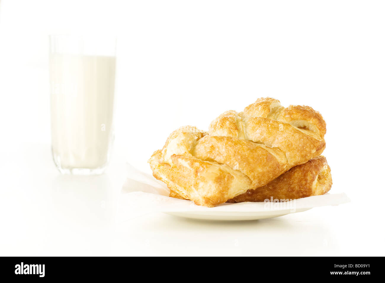 Weißen Teller mit frisch gebackenem Gebäck mit Glas Milch auf weißem Hintergrund Stockfoto