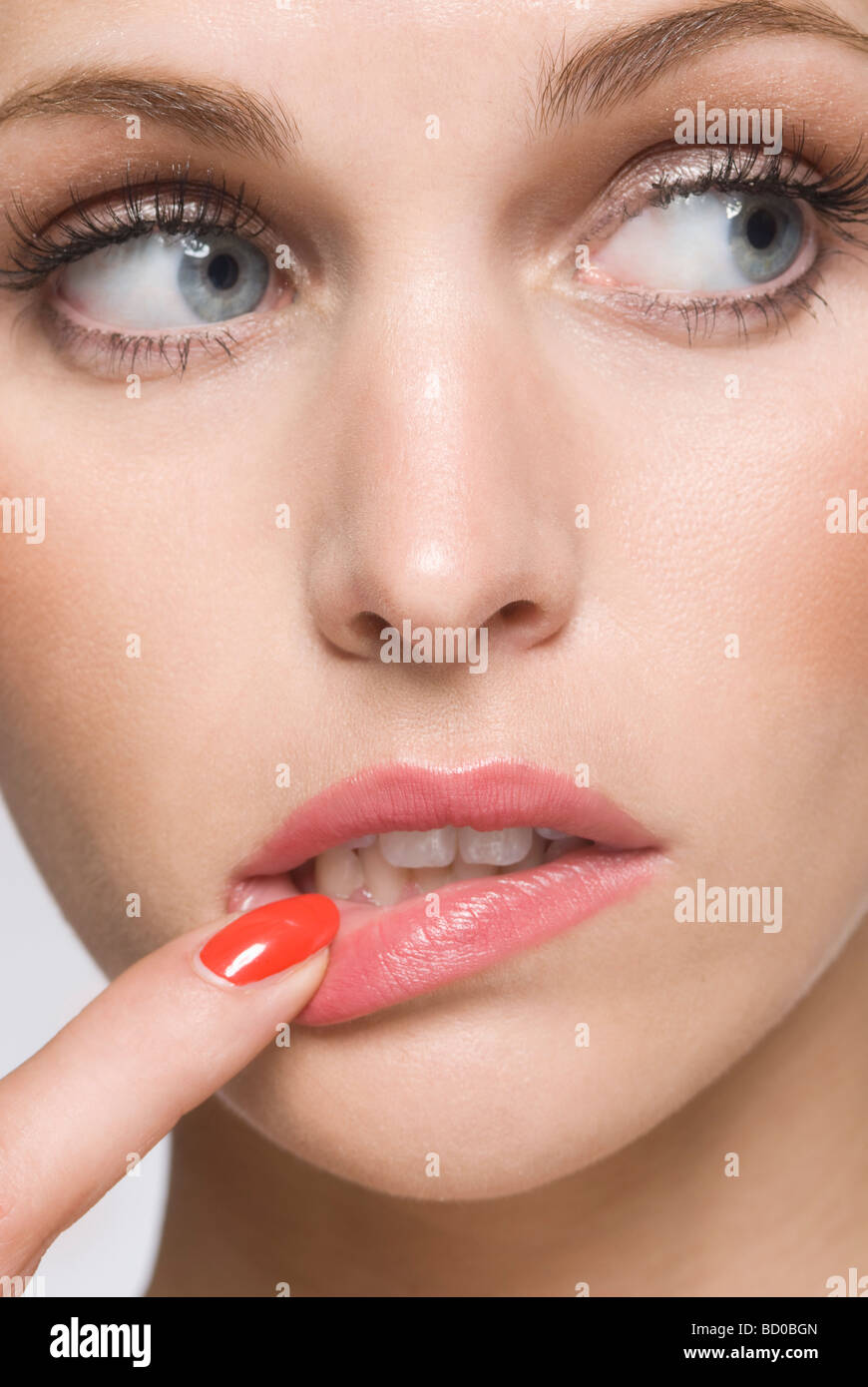 weibliche Schönheit mit Finger im Mund Stockfoto