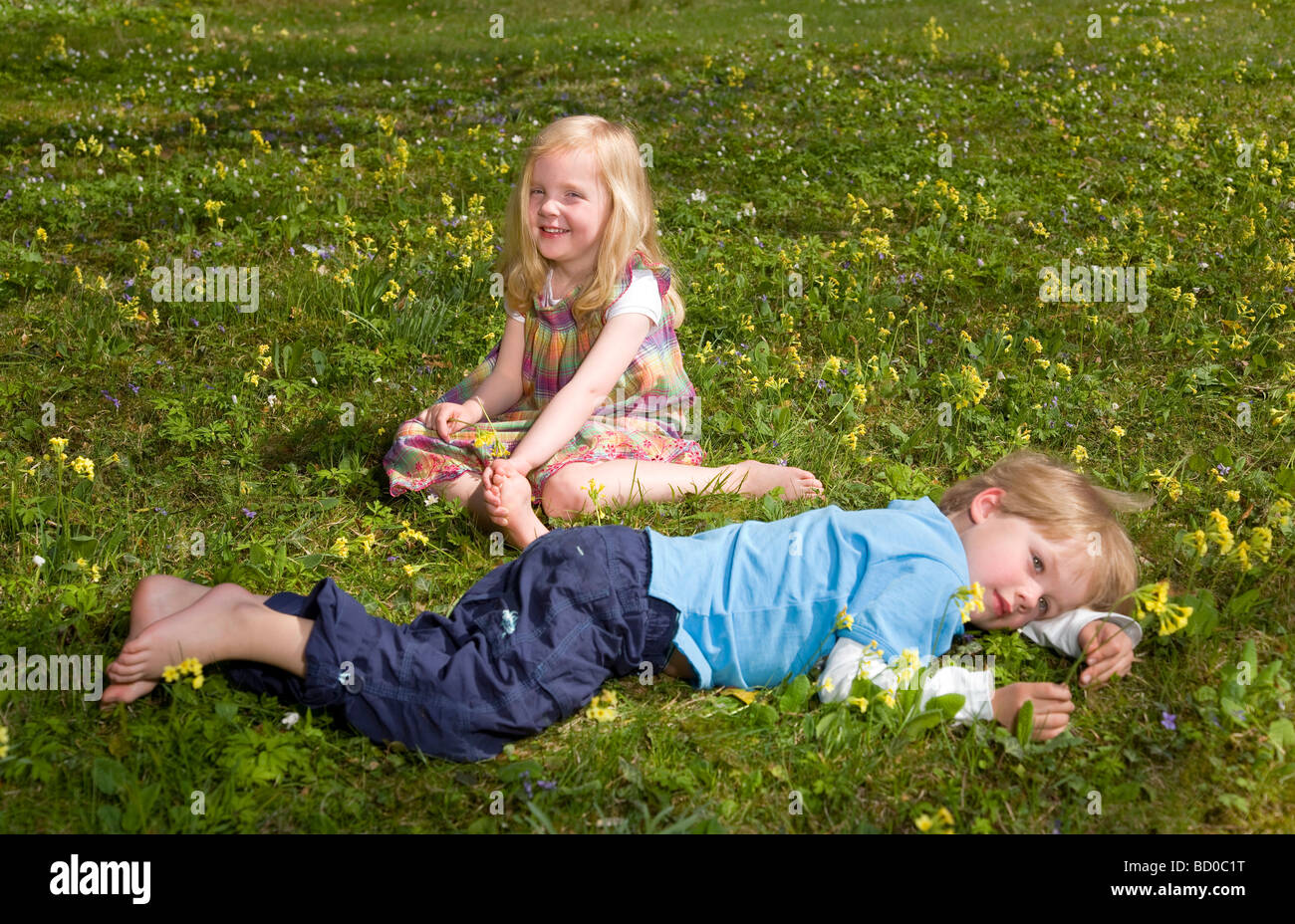 Mädchen und jungen im Grass liegen Stockfoto