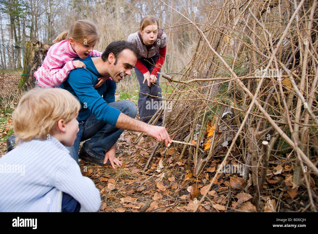 Junge, Mädchen, Mann Beleuchtung Lagerfeuer Stockfoto