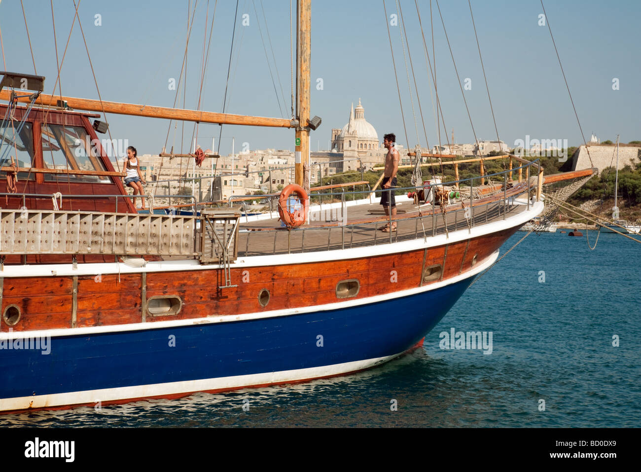Ein junges Paar an Bord eine alte hölzerne Segelschiff, Hafen von Sliema, Valletta, Malta Stockfoto