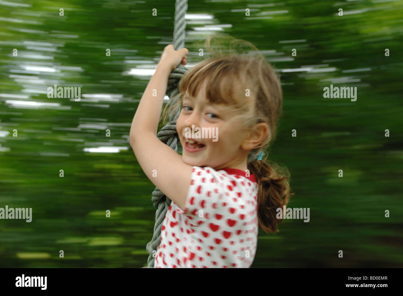 Junges Mädchen auf einem Seil schwingen Stockfoto