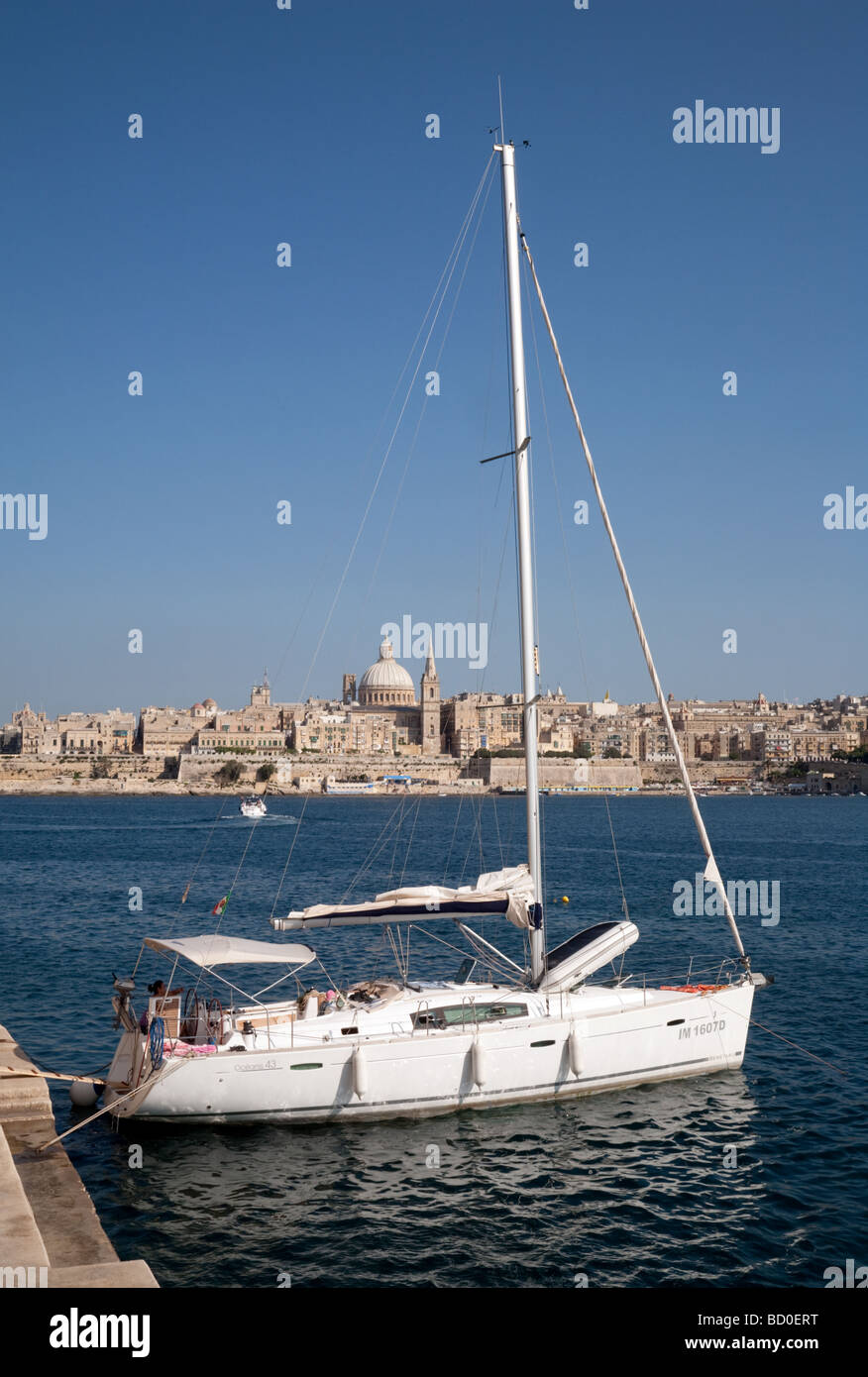 Eine Yacht ankern in Sliema, Valletta Skyline im Hintergrund, Sliema, Malta Stockfoto