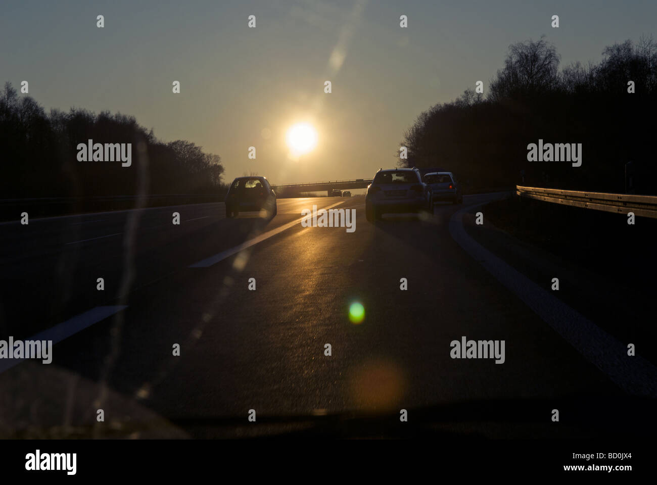 Fahren auf der Autobahn in einer untergehenden Wintersonne Stockfoto
