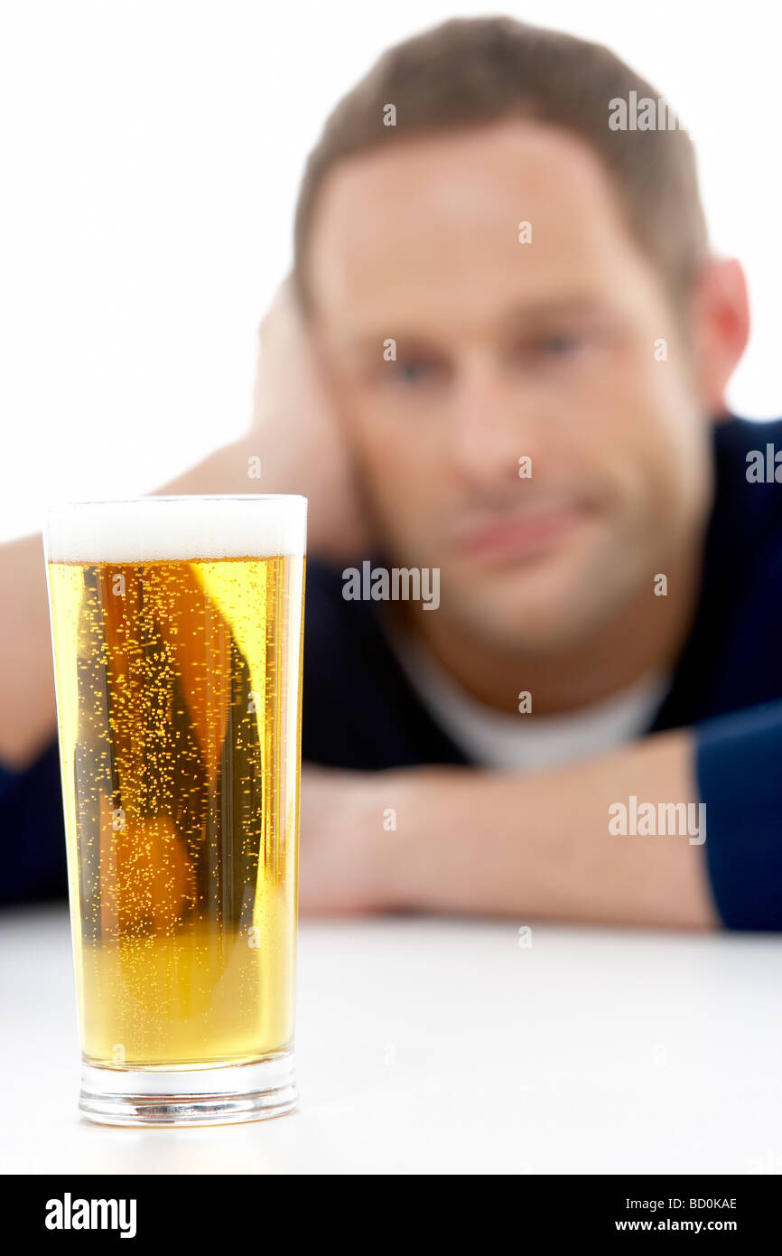 Man Looking At Glas Bier Stockfoto
