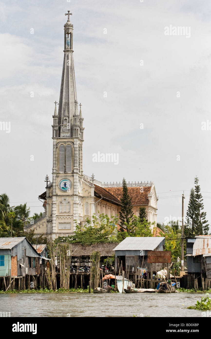 Eine Kirche hinter einem schwimmenden Dorf im Mekong Delta, Vietnam Stockfoto