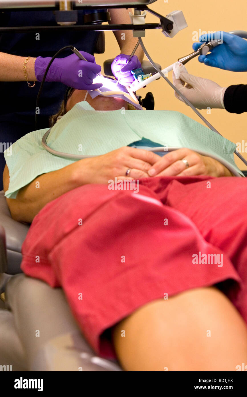 Eine Patientin erhält eine Wurzelbehandlung von einer Zahnärztin. Stockfoto