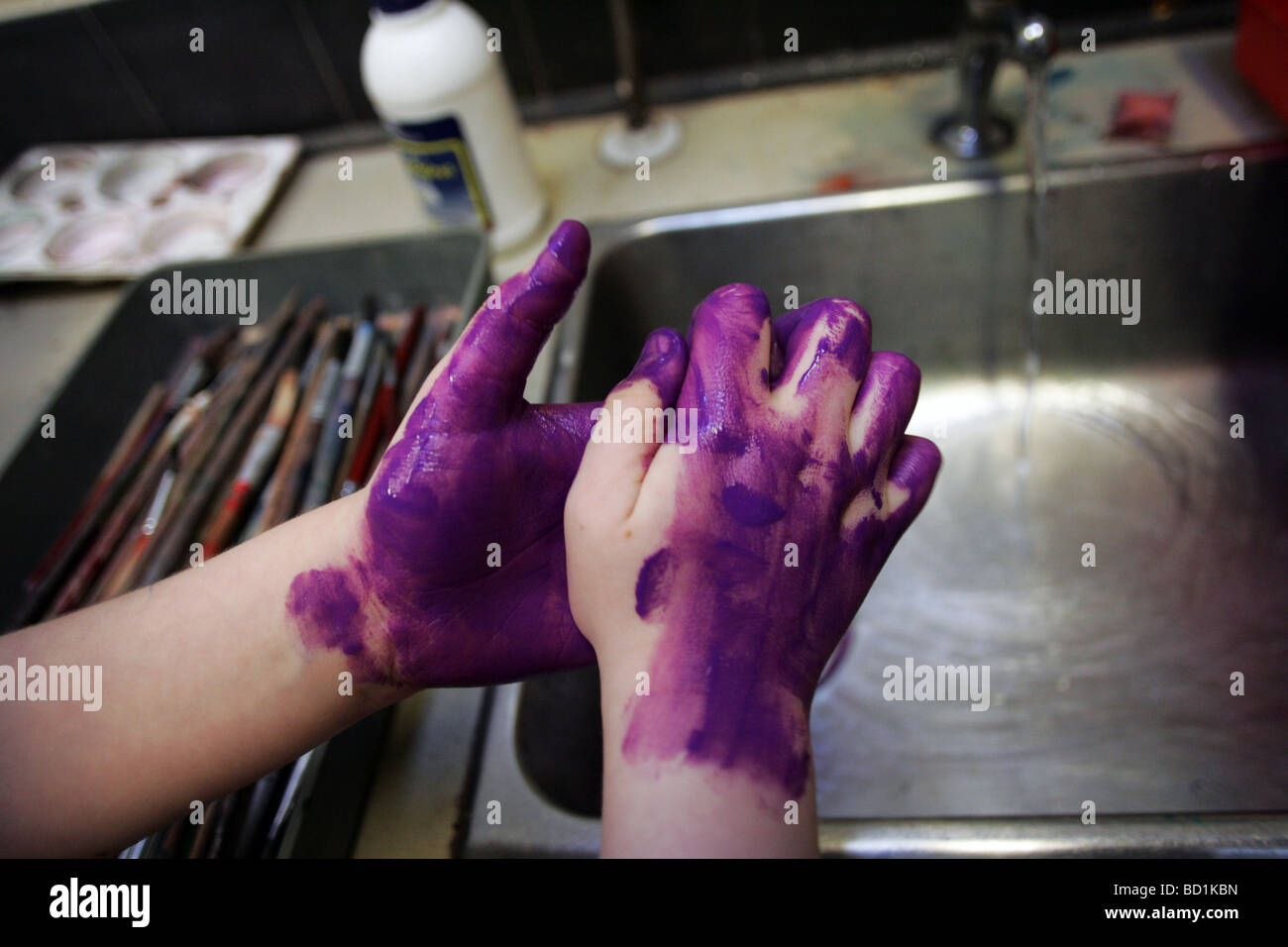 Ein Kind wäscht seine Hände nach einer Schule-Malerei-Sitzung Stockfoto