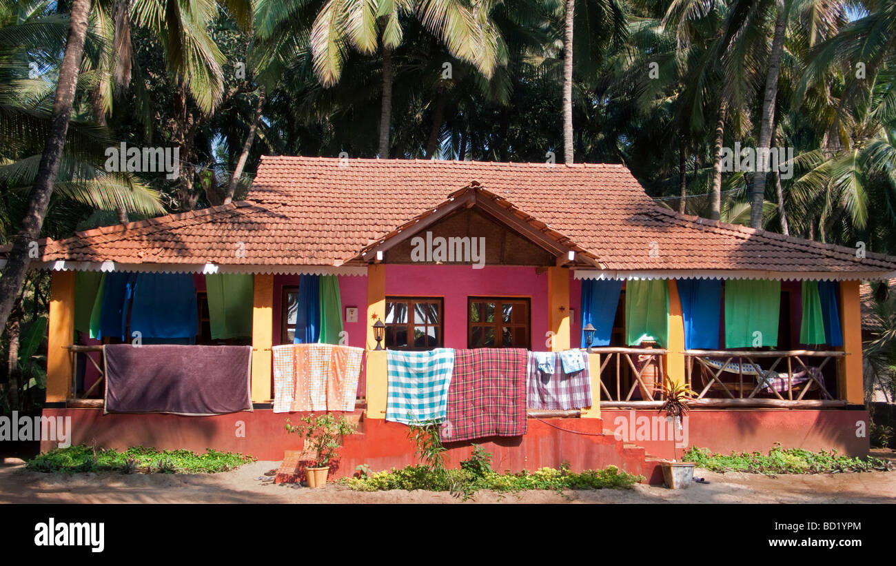 Bunte Haus in Palmen mit Wäsche trocknen Goa Südindien Stockfoto