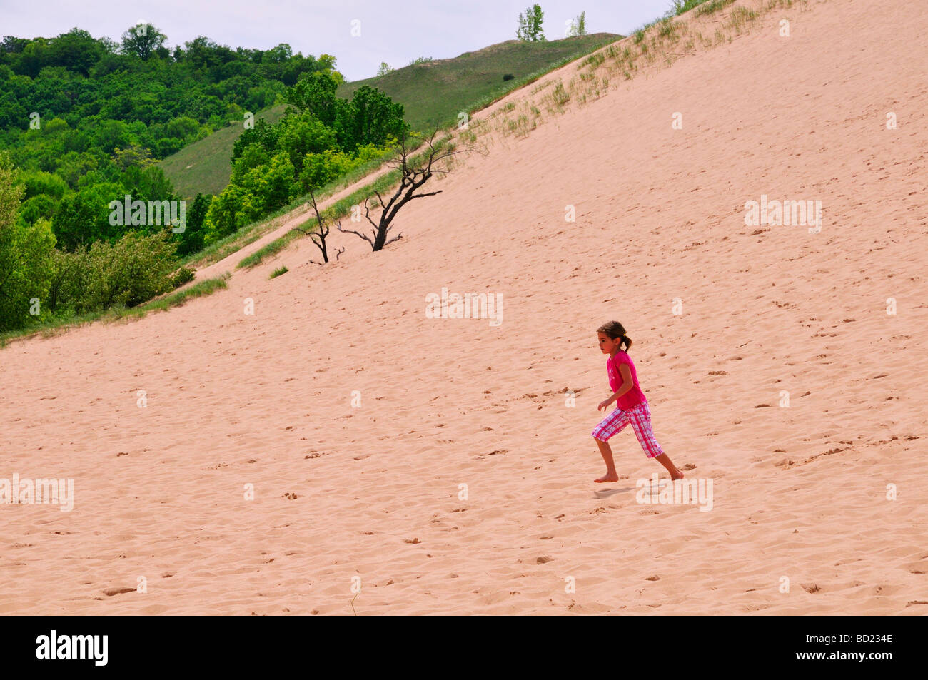 Ein junges Mädchen läuft eine Sanddüne in Sleeping Bear Dunes National Lakeshore Stockfoto