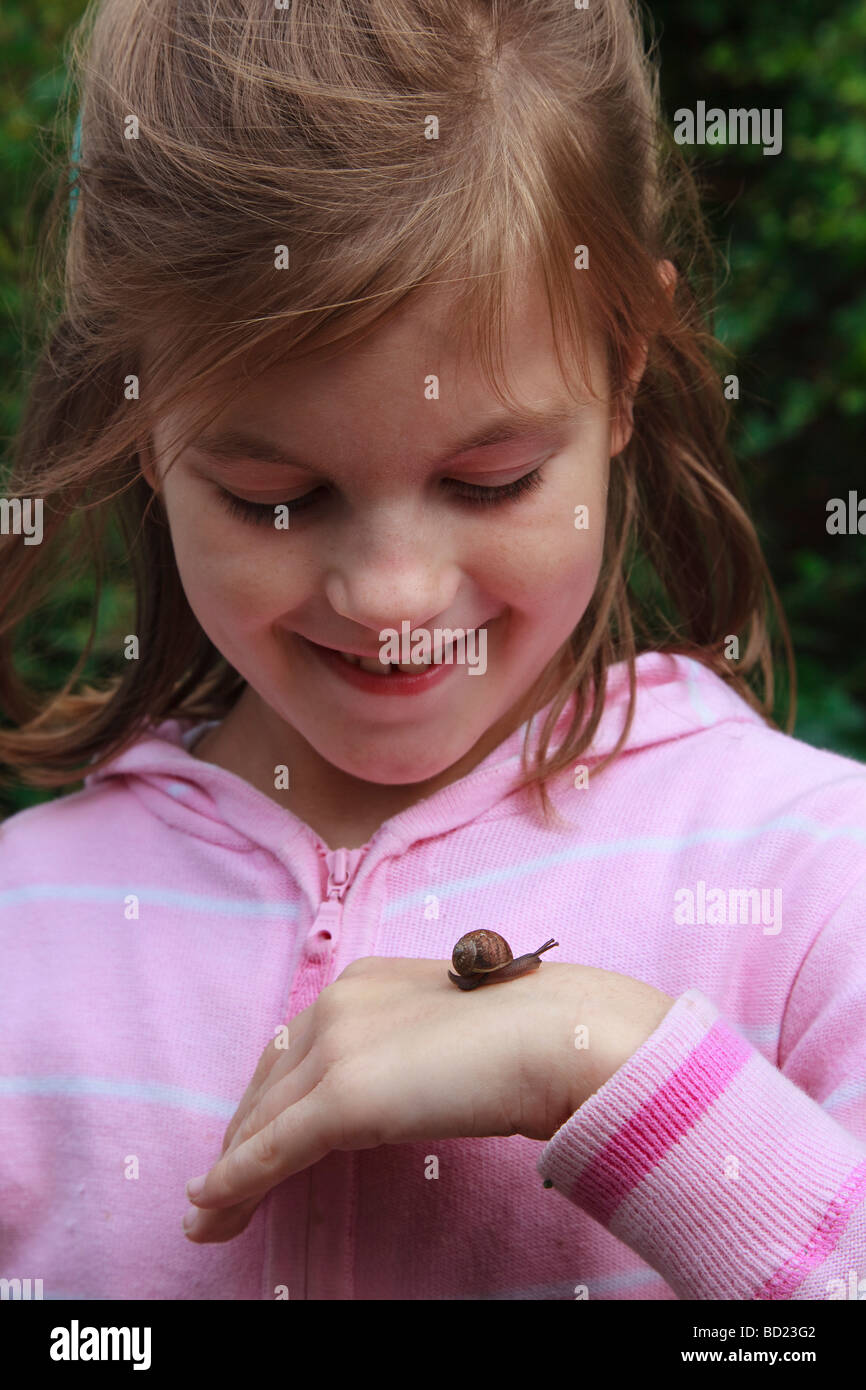 Junges Mädchen mit Schnecke kriecht in die hand Stockfoto