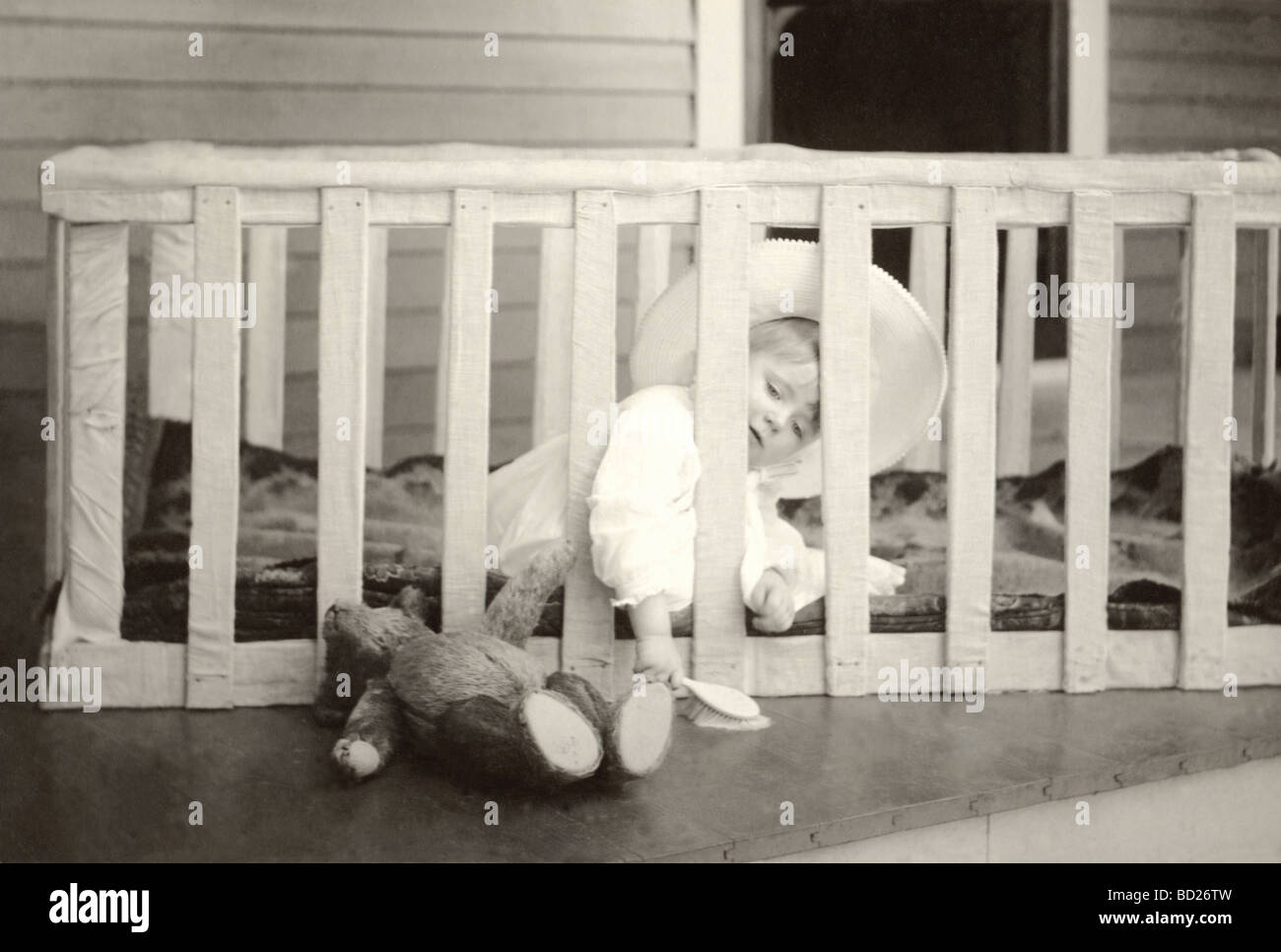 Kleinkind in großen Hut im Laufstall auf Veranda Stockfoto