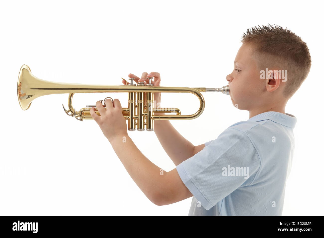 kleiner Junge bläst in eine Trompete vor weißem Hintergrund Stockfoto