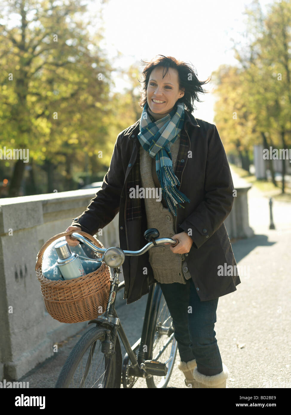 Frau mit Fahrrad auf Brücke im Herbst Stockfoto