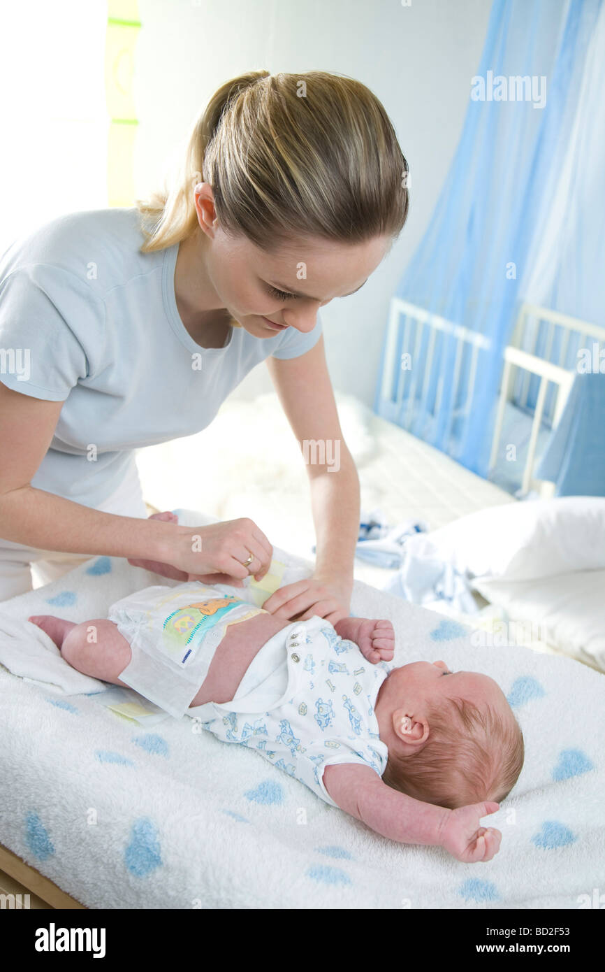 Mama, die Windel anziehen Stockfoto