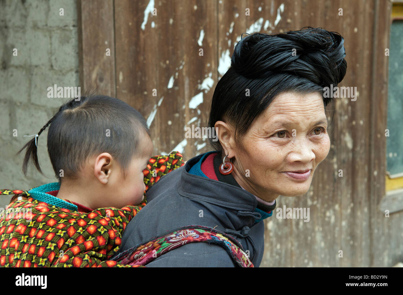 Dong Minderheit Mutter mit Kind auf Rücken Tangan Dorf Guizhou China Stockfoto