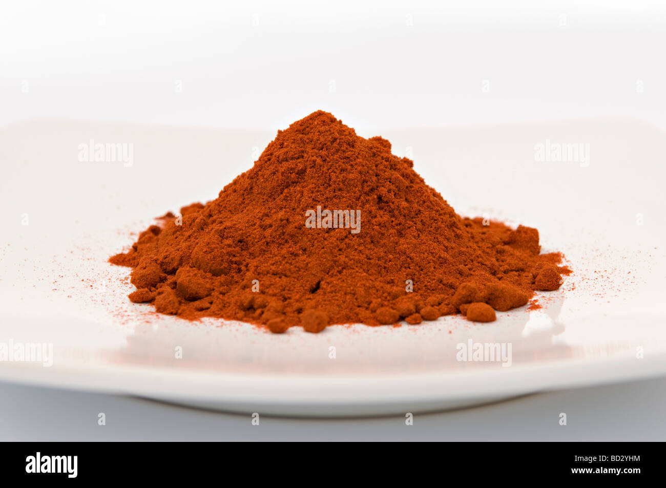 Chili-Pulver oder Paprika auf weißen Teller genommen vor weißem Hintergrund Stockfoto