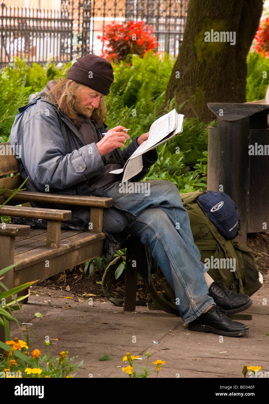 Obdachloser lesen Zeitung Stockfoto