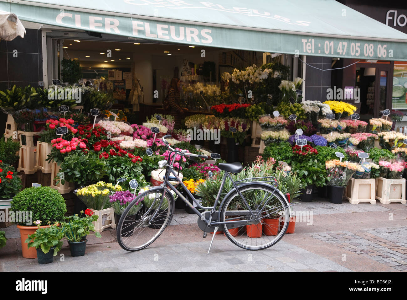 Ein traditionelles Fahrrad steht vor einem Blume Stand an der Rue Cler in Paris, Frankreich Stockfoto