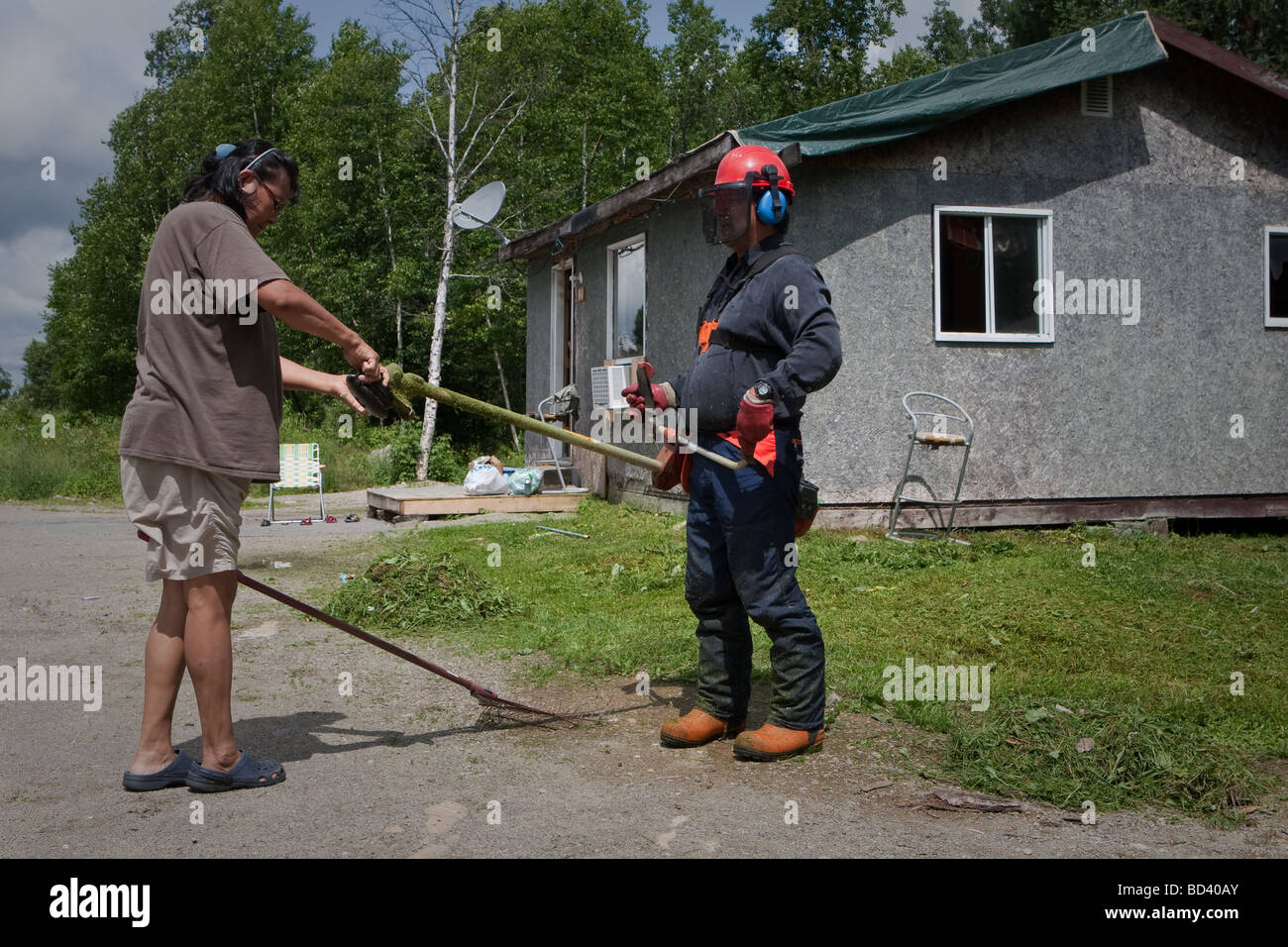 Eine Frau ihrem Ehemann Weedeater in der Algonquin reinigen Anicinape Gemeinschaft von Kitcisakik in Quebec Kanada Stockfoto