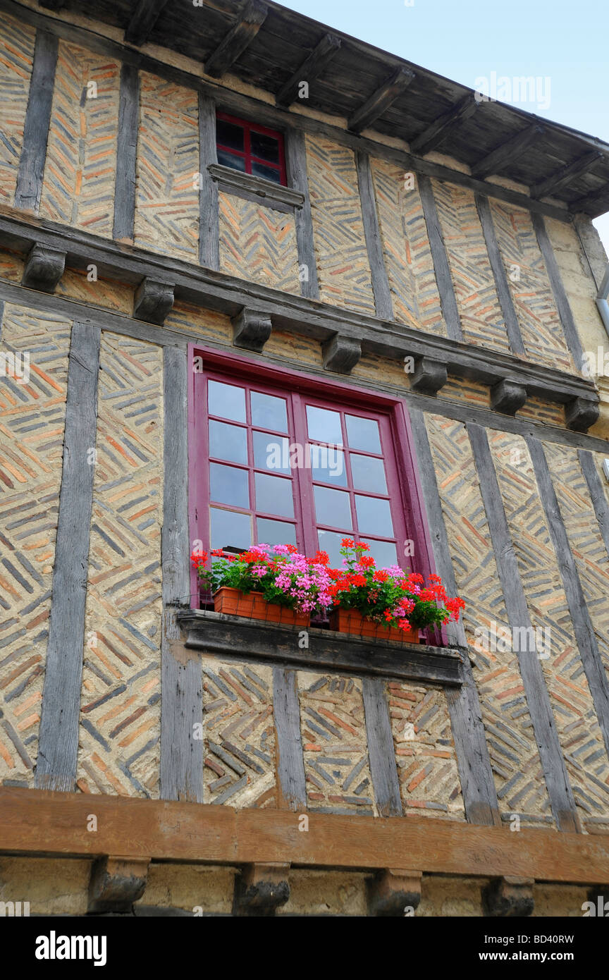 "Nahaufnahme von alten historischen mittelalterlichen Fachwerk Haus und Fenster mit Blumen in voller Blüte in Frankreich Stockfoto