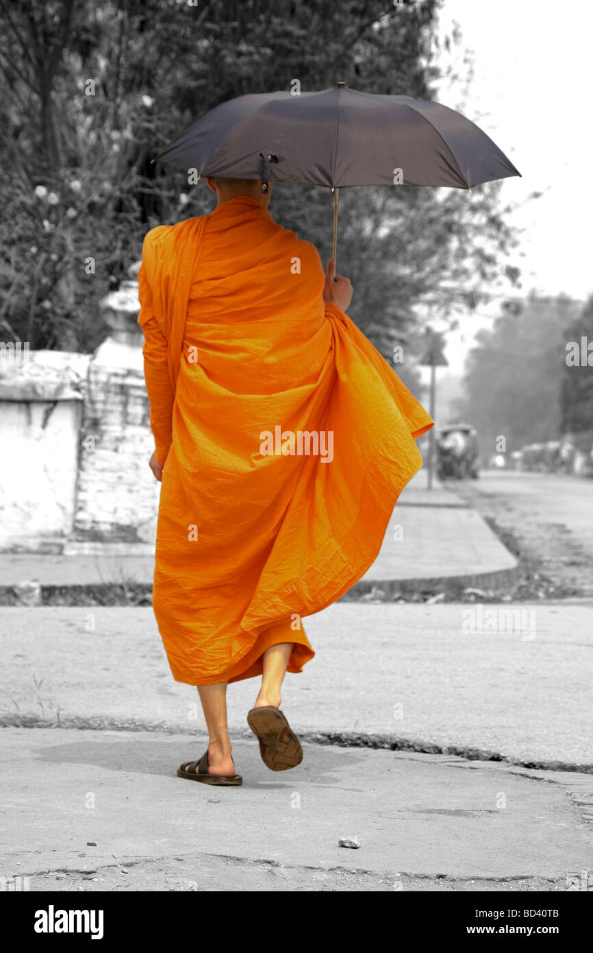 Buddhistischer Mönch zu Fuß die Straße runter in Luang Prabang, Laos Stockfoto