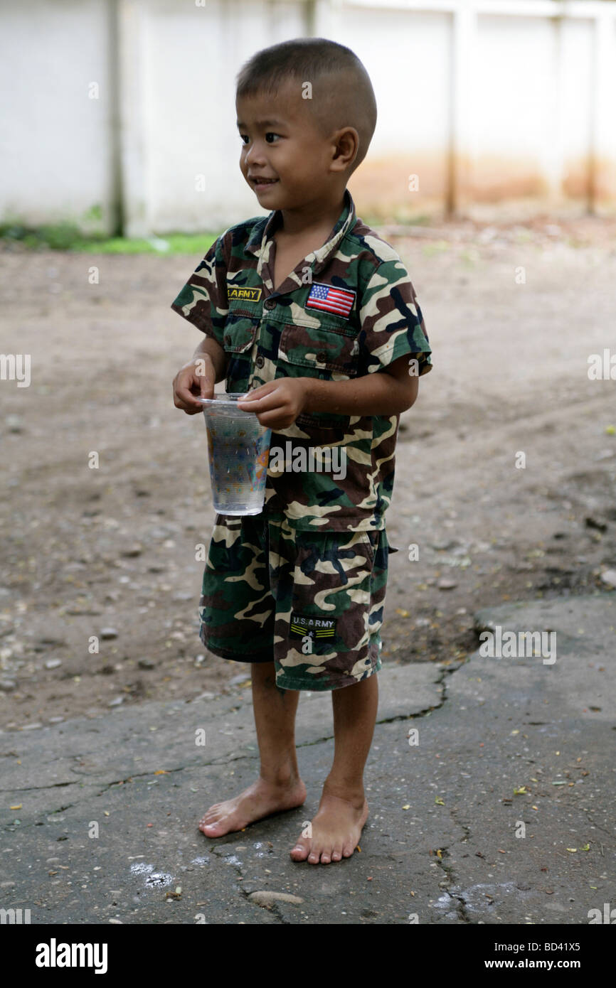 Vientiane, Laos, 2006: Ein kleiner Junge auf dem Gelände des Tempels trägt militärische Tarnung Stockfoto