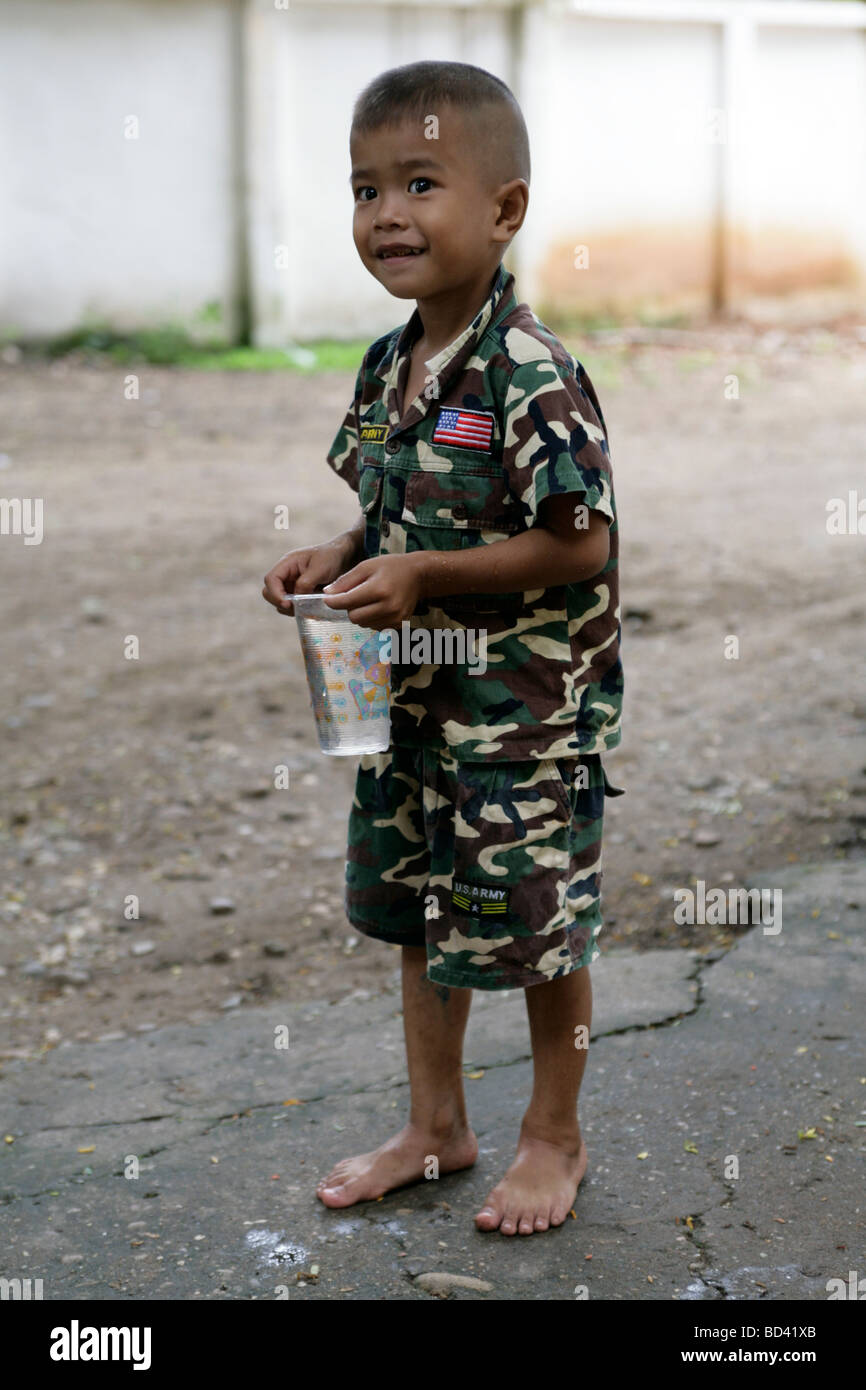 Vientiane, Laos, 2006: Ein kleiner Junge auf dem Gelände des Tempels trägt militärische Tarnung Stockfoto
