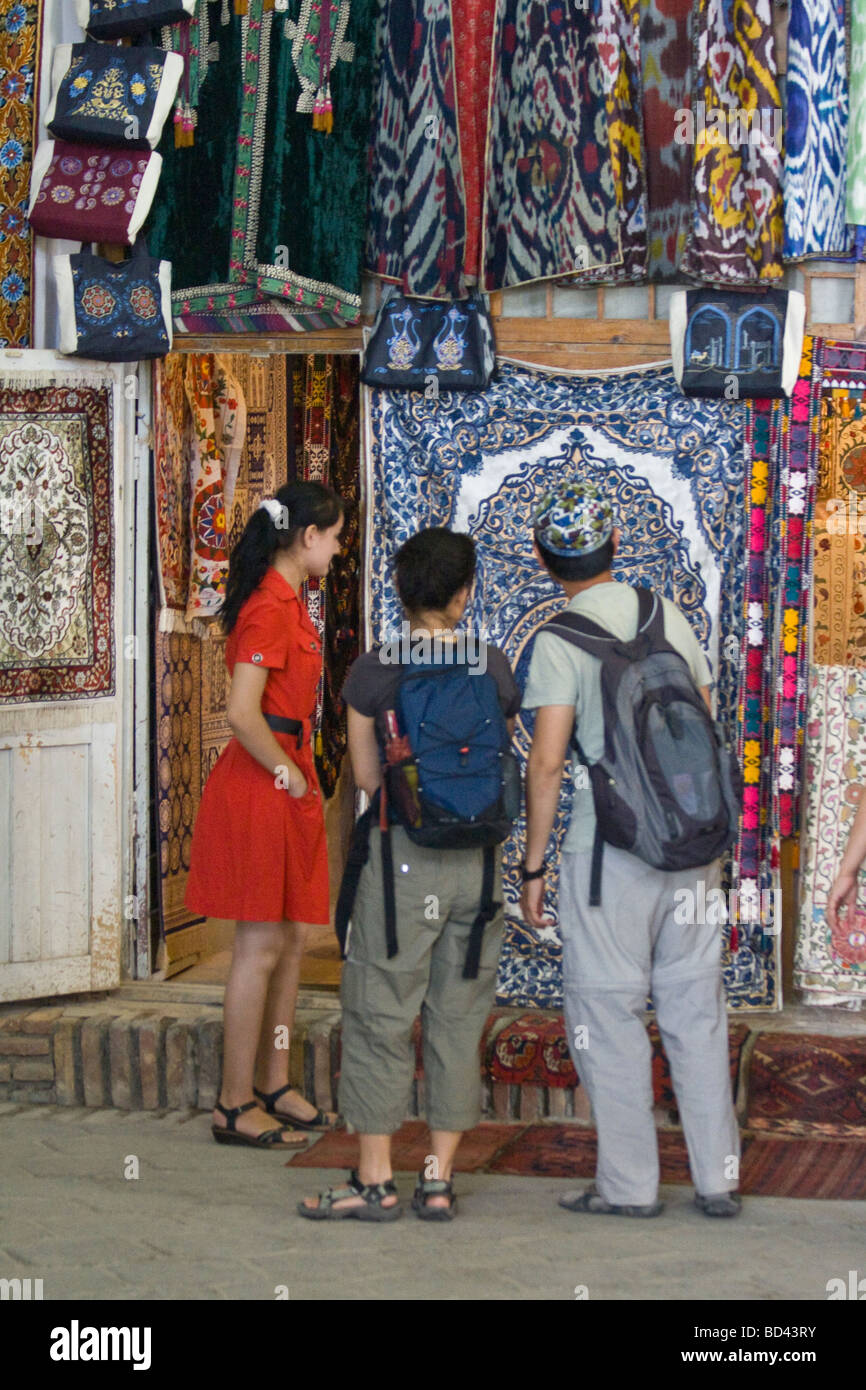 Touristen-Shopping für usbekische Textilien in einem der Handel Kuppeln in Buchara Usbekistan Stockfoto