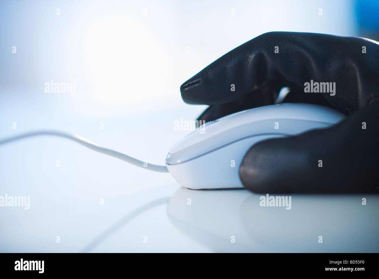 Eine behandschuhte Hand auf einer Computer-Maus Stockfoto