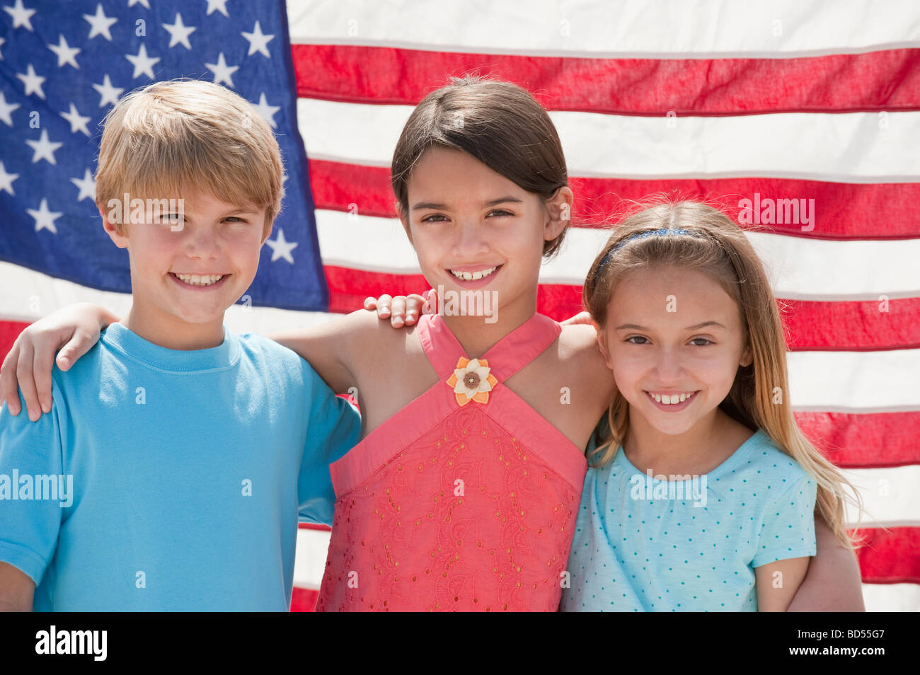 Drei Kinder vor einer amerikanischen Flagge Stockfoto