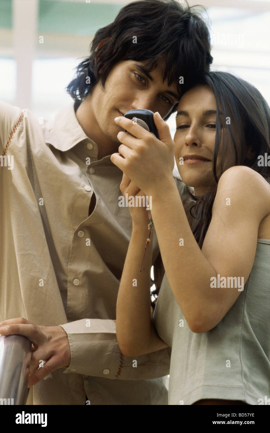 Junges Paar Blick auf Handy zusammen Stockfoto