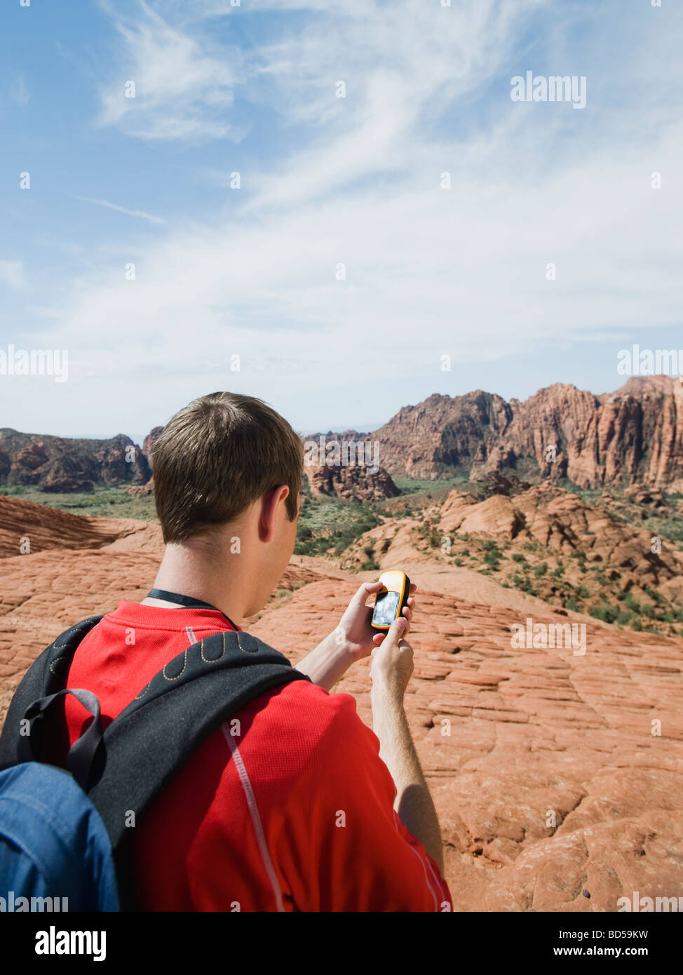 Ein Mann im roten Rock hält ein GPS-Gerät Stockfoto