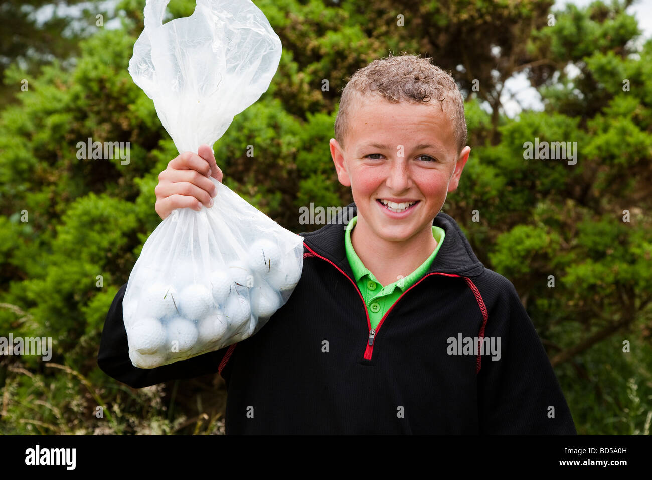 Kleiner Junge sammeln Golfbälle auf einem Golfplatz Stockfoto