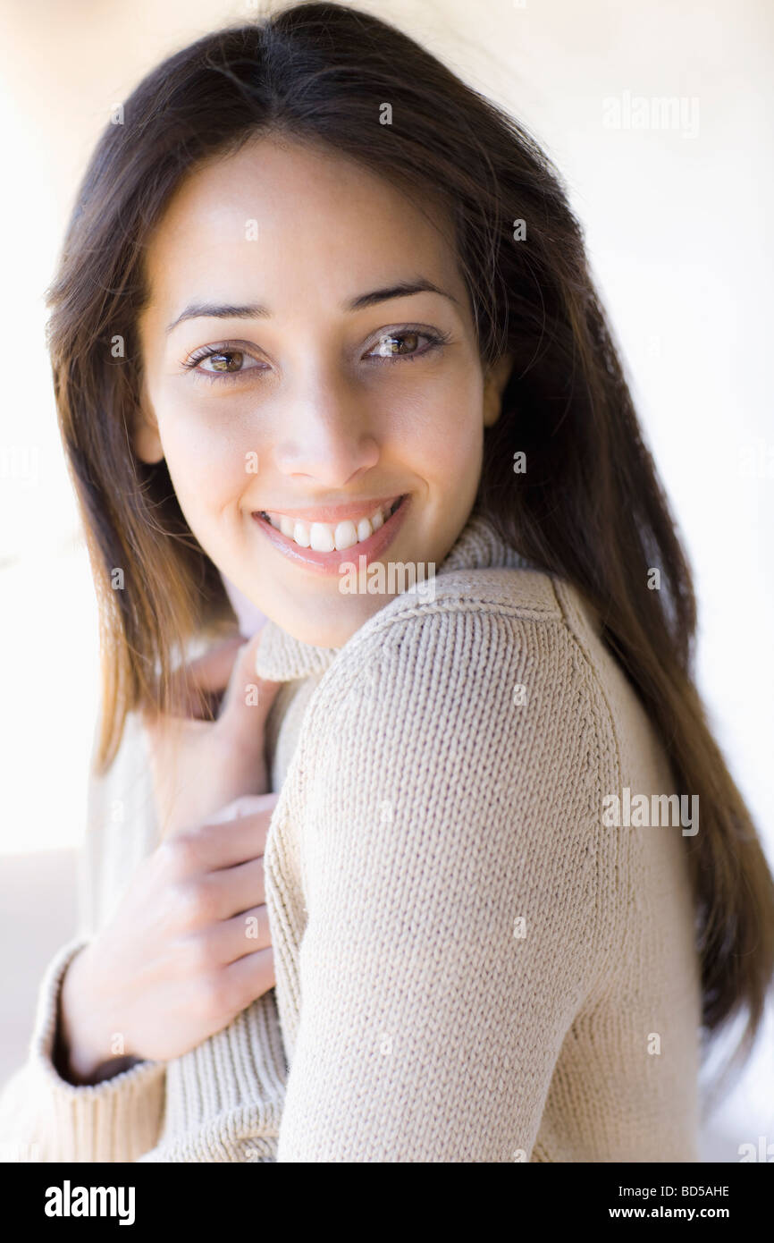 Eine Frau lächelt und huggin Arme, Brust Stockfoto