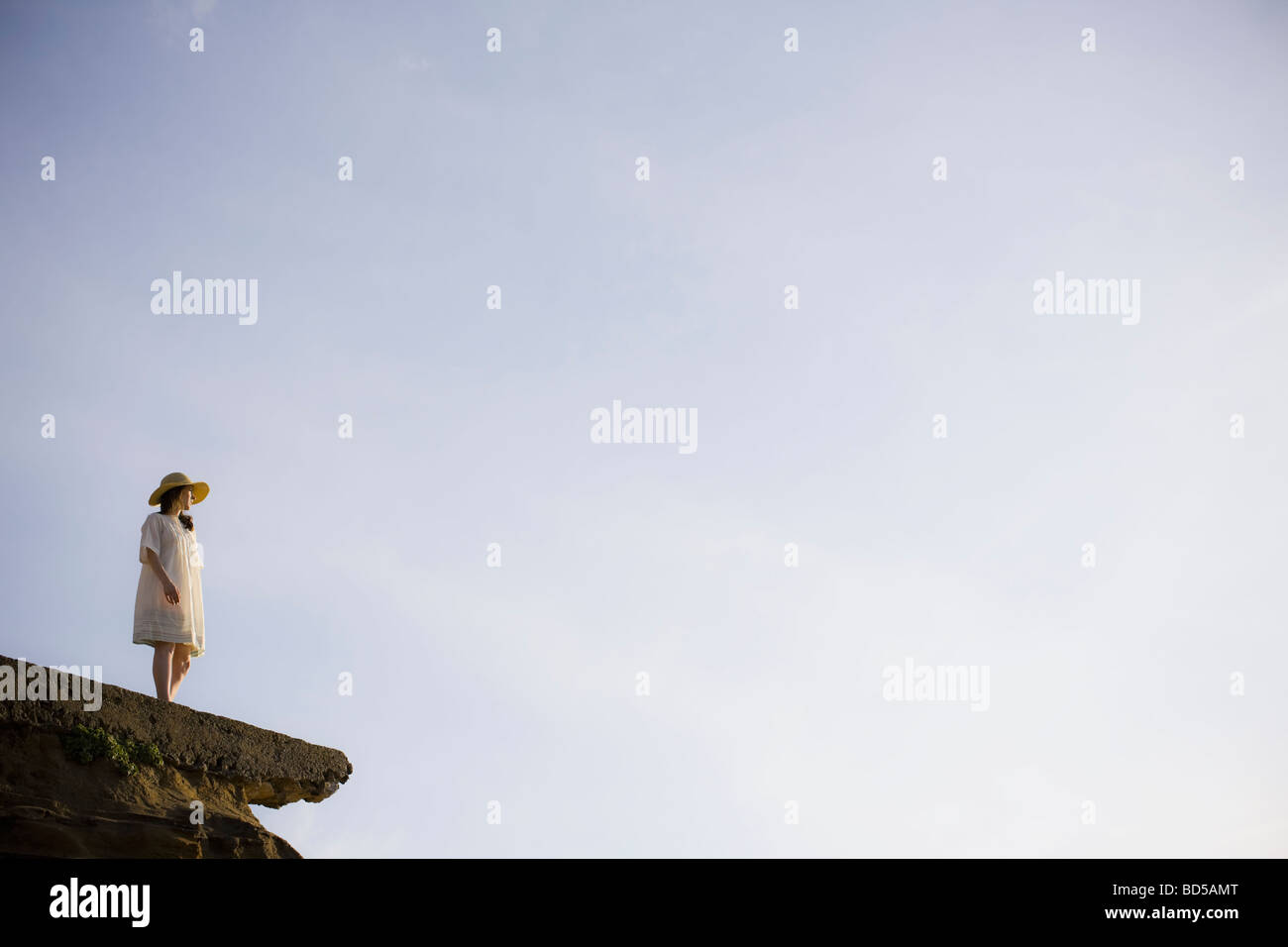 Eine Frau steht auf einer Klippe Stockfoto