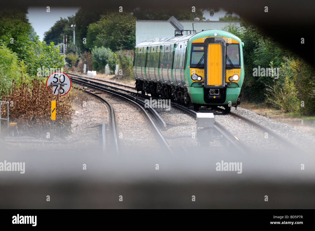 Royalty free Foto Eisenbahn Zug auf Schienen Annäherung an Bahnübergang in London UK Stockfoto
