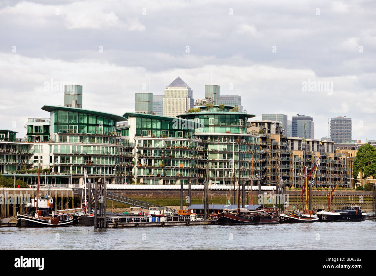 Typische Themse am Flussufer Privatwohnungen Wapping East End London England UK, mit Canary Wharf im Hintergrund Stockfoto