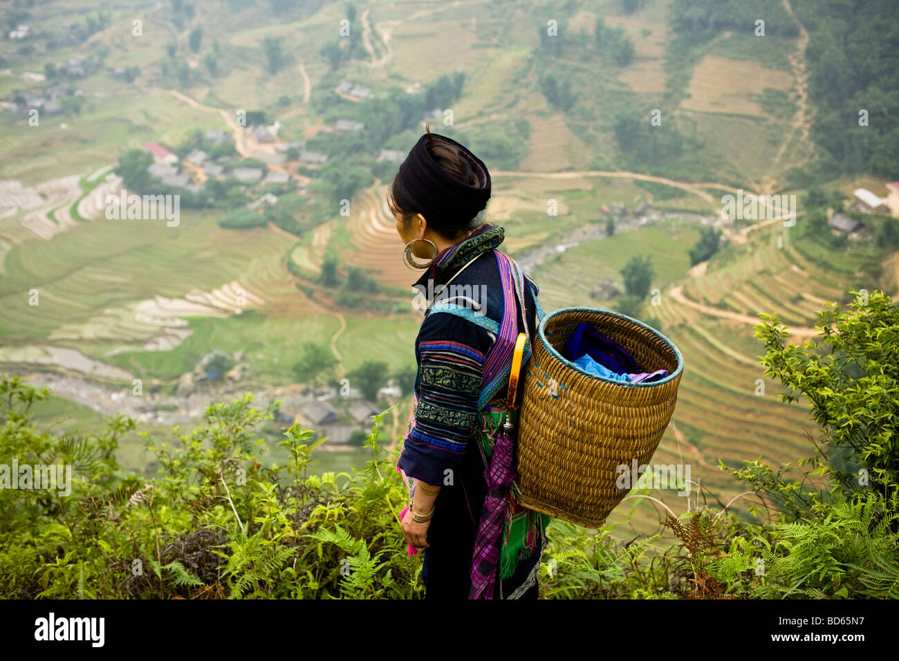 Eine Frau vom Stamm Black Hmong-Hügel in Sapa Vietnam steht und mit Blick auf die Reisterrassen unten im Tal Stockfoto