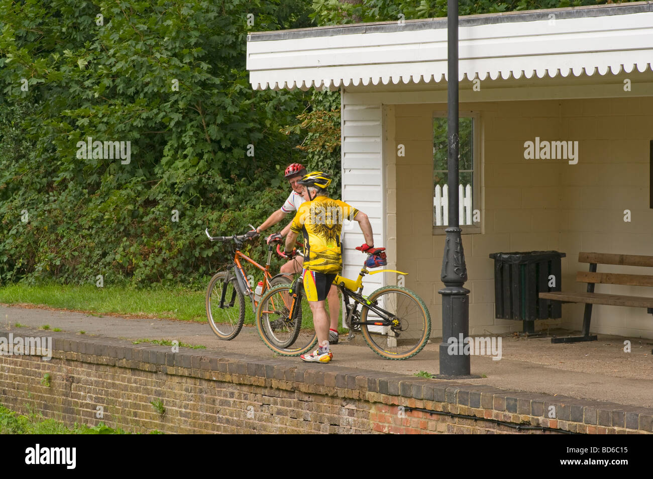 2 ältere Radfahrer ruhen auf den stillgelegten Bramley und Wonersh Bahnhof auf den Downs verknüpfen Stockfoto