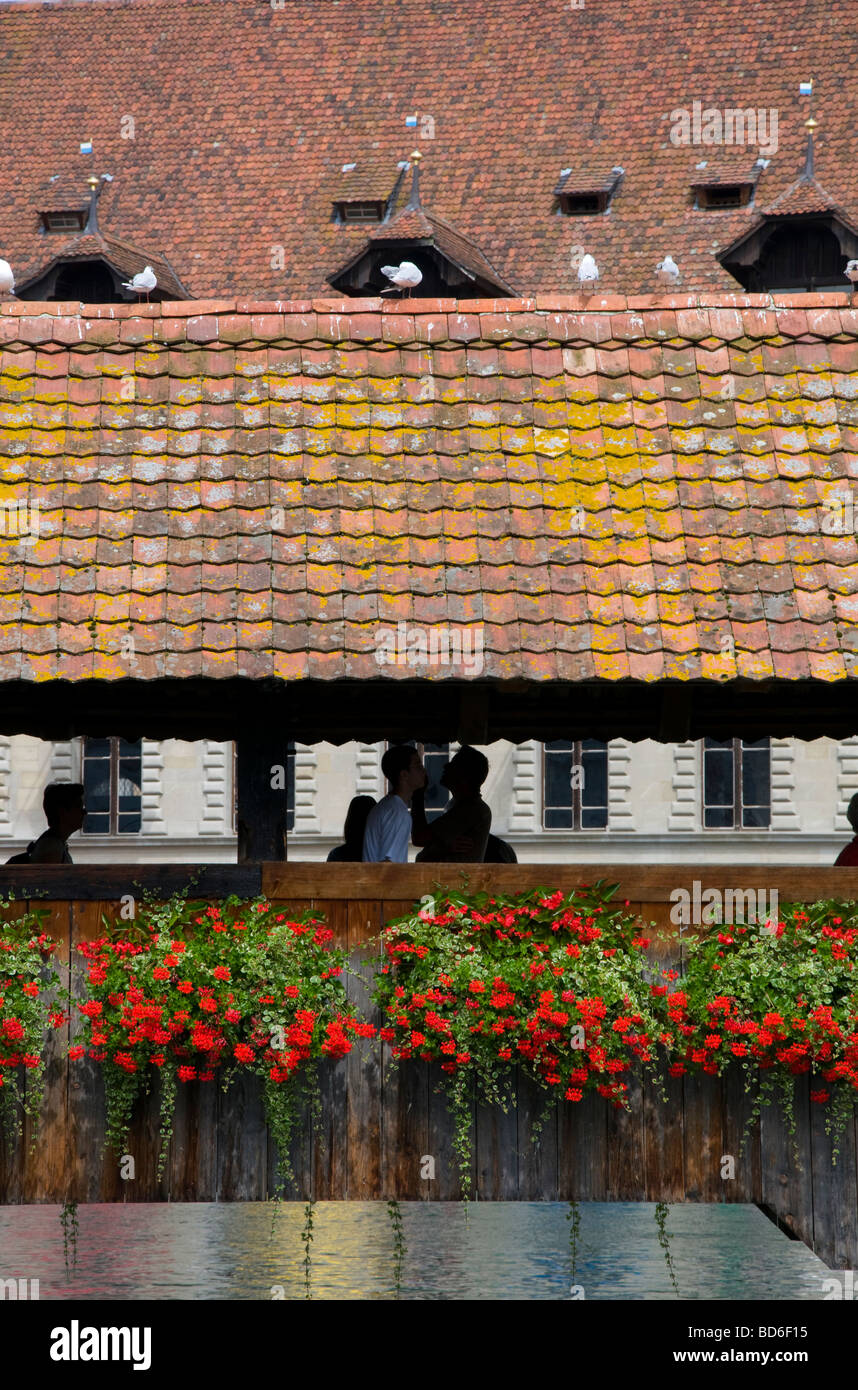 Luzern / Luzern, Schweiz. Kapellbrucke (1333, nach Brand im Jahr 1993 restauriert) Menschen in der Silhouette / Möwen auf Dach Stockfoto