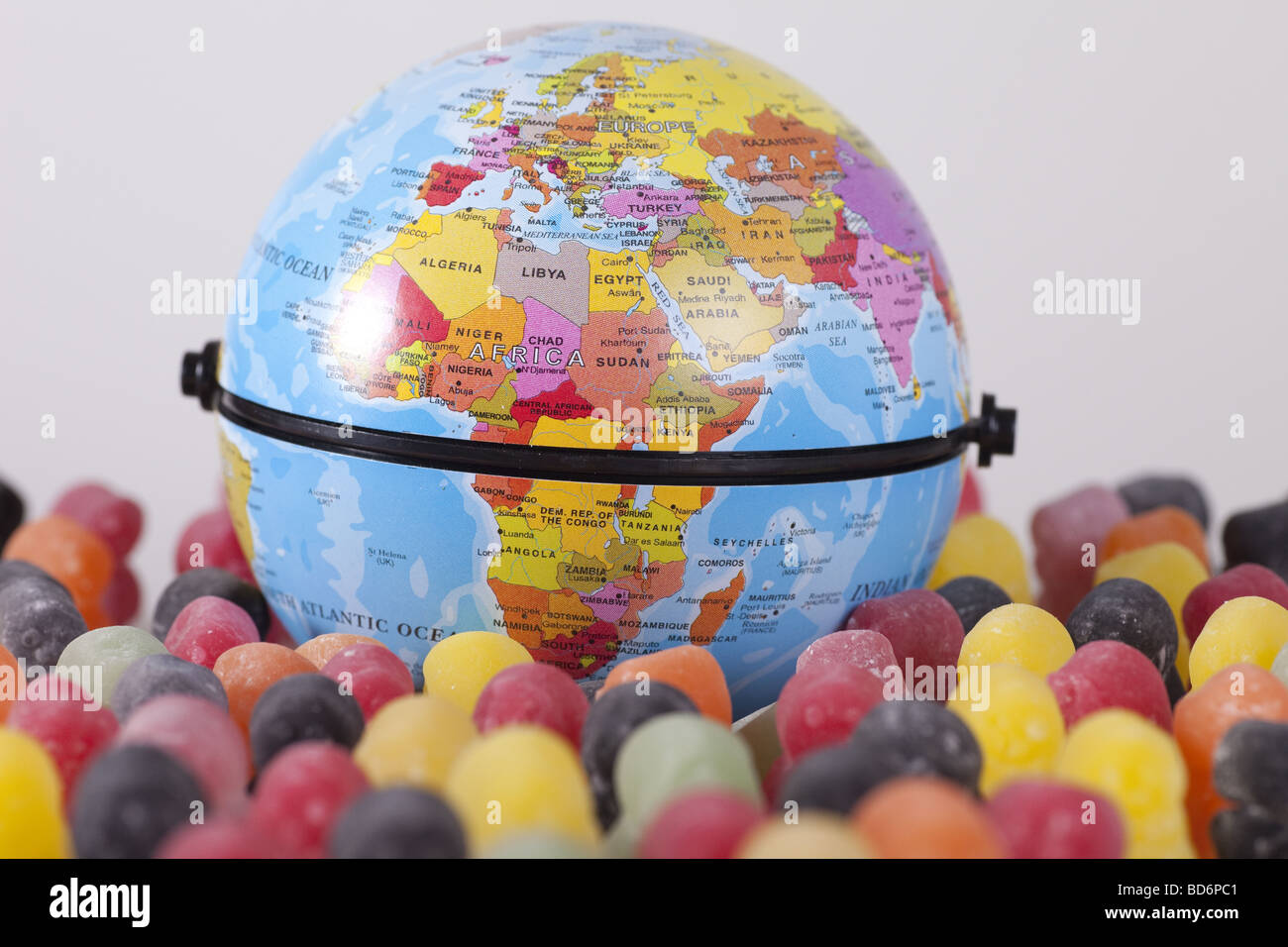 kleine Welt Spiel mit Gummibärchen und Weltkugel Stockfoto