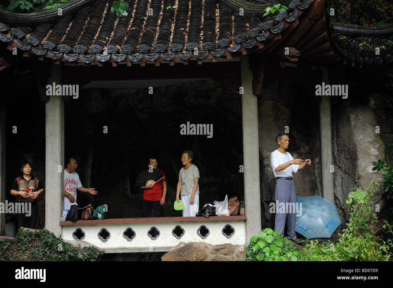 Menschen singen traditionelle Oper oder üben Taiji in der Nähe von Liuyi Brunnen am Fuße des Hügels Gushan in Hangzhou, China. Stockfoto