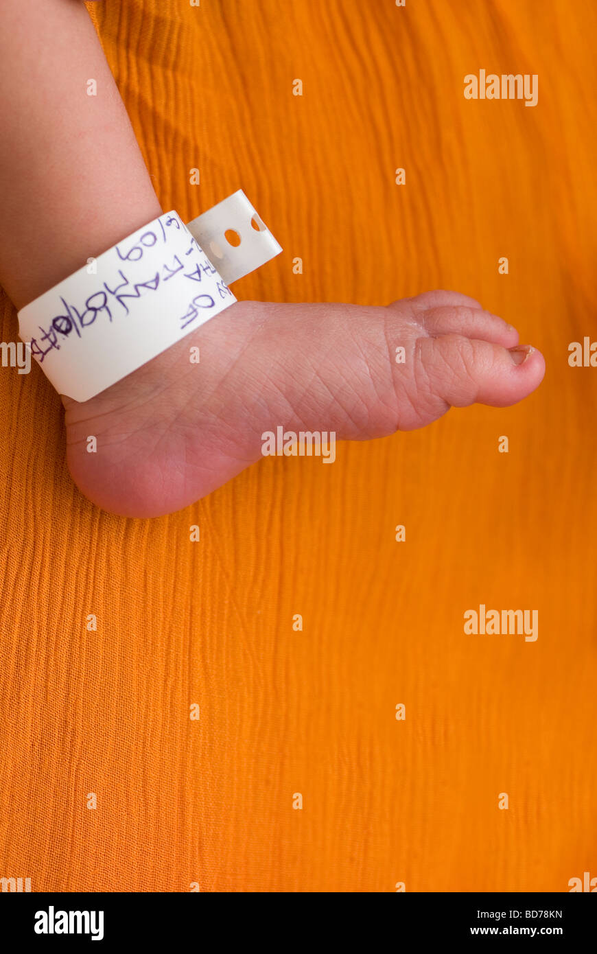 Neugeborenes Baby Fuß mit Tag um den Knöchel im Krankenhaus Stockfoto