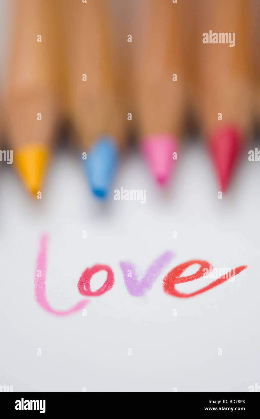 Farbige Liebe Wort auf Papier und Buntstifte Stockfoto