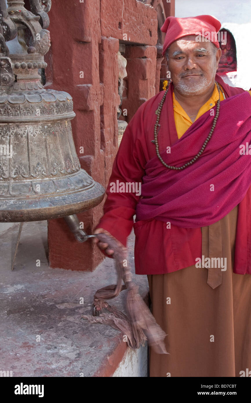 Bodhnath, Nepal. Buddhistischer Mönch im Buddhistischen Stupa von bodhnath Ringe Glocke zu fahren Sie böse Geister. Stockfoto