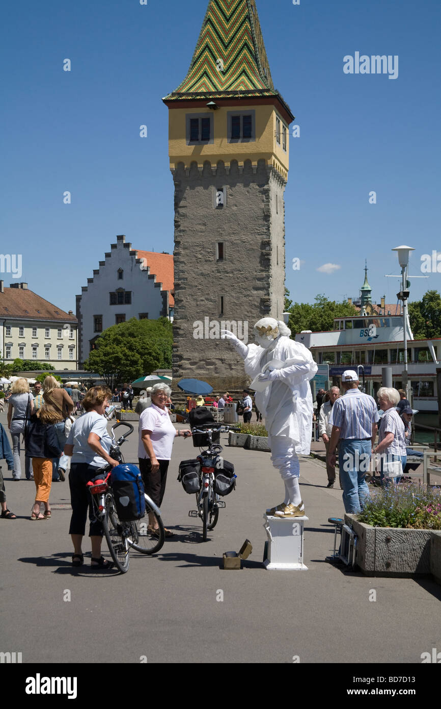 Lindau Bayern Deutschland Pantomime auf der breiten Fußgängerzone Promenade vor Mangturm von weiblichen Radfahrer beobachtet Stockfoto